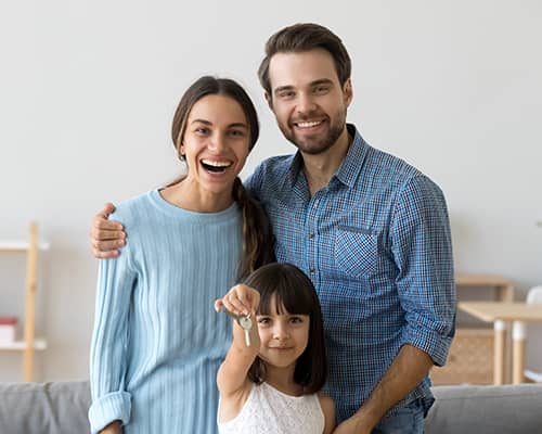 Little Daughter Showing New Home Keys Standing With Parents and Smiling in Houston